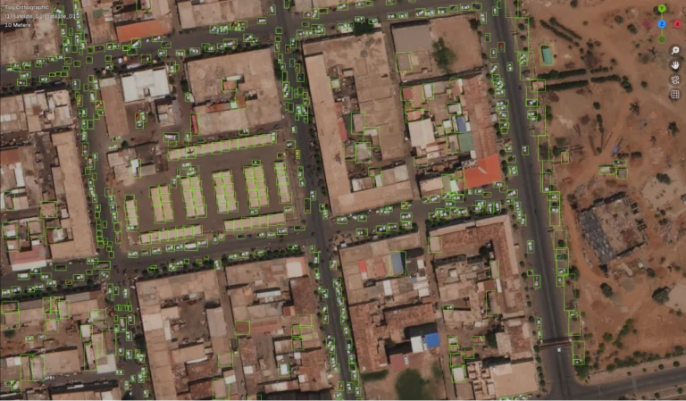A satellite RGB scene where an AI inpainting tool has isolated and set bounding boxes around all of the automotive vehicles.
